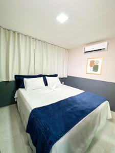a bedroom with a large bed with blue and white sheets at Hotel Haki in Patos