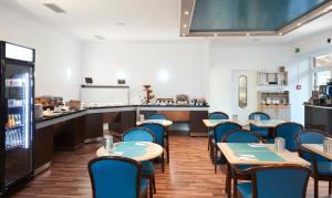 a restaurant with tables and chairs and a counter at Living Hotel am Olympiapark in Munich