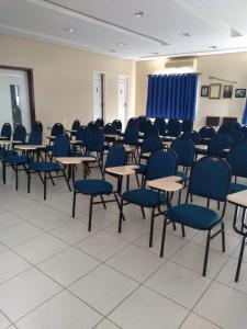 una habitación llena de mesas y sillas con sillas azules en Real Hotel Empreendimentos, en São Raimundo Nonato