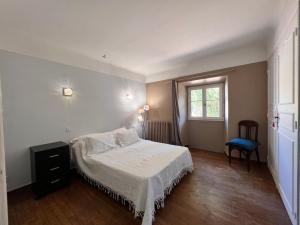 ein kleines Schlafzimmer mit einem Bett und einem Fenster in der Unterkunft Bergerie de l'Horte in Tourouzelle