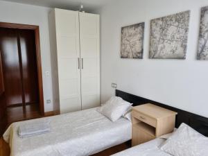 1 dormitorio con 2 camas y armario en Piso zona hospital 7 personas, en Oviedo