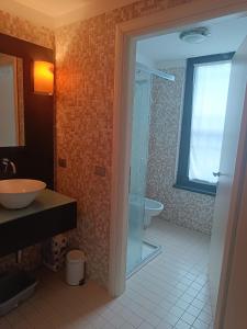 W łazience znajduje się szklana kabina prysznicowa i umywalka. w obiekcie Loft Certosa District con parcheggio privato w Mediolanie
