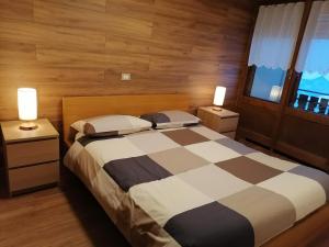 a bedroom with a bed with two night stands and two lamps at Casa Flippola - Trilocale Santa Caterina Centro Paese in Santa Caterina Valfurva +8 photos