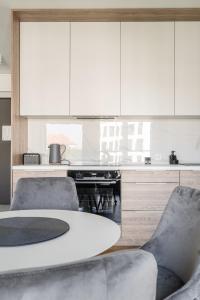 a kitchen with a table and chairs and white cabinets at RentPlanet - Apartamenty Księcia Witolda in Wrocław