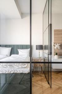 een slaapkamer met een bed en een glazen wand bij RentPlanet - Apartamenty Księcia Witolda in Wrocław