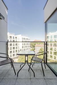 een tafel en 2 stoelen op een balkon met uitzicht bij RentPlanet - Apartamenty Księcia Witolda in Wrocław