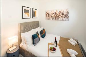 a bedroom with a bed and a table with a bottle of wine at Smart Living Sophisticated Style - Photo ID Required in London +18 photos