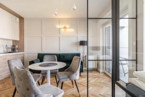 een woonkamer met een tafel en stoelen bij RentPlanet - Apartamenty Księcia Witolda in Wrocław