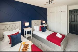 a bedroom with two beds and a blue wall at Smart Living Sophisticated Style - Photo ID Required in London