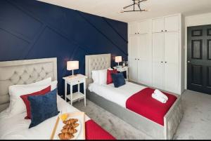a bedroom with two beds and a blue wall at Smart Living Sophisticated Style - Photo ID & Deposit Required in London