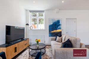 a living room with a couch and a tv at Dorking - Brand New 1 Bedroom Apartment in Dorking