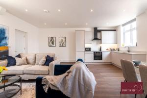 a living room with a couch and a kitchen at Dorking - Brand New 1 Bedroom Apartment in Dorking