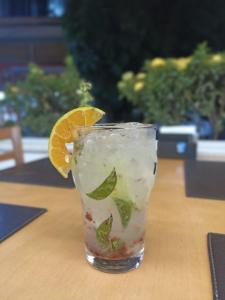 a drink with an orange slice on a table at Real Hotel Empreendimentos in São Raimundo Nonato