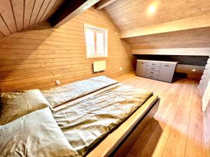 a large bed in a room with a wooden wall at Vila Scandinavia in Sîngeorgiu de Mureş