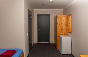 1 dormitorio con 1 cama, puerta y nevera en Kuremaa Külalistemaja en Kuremaa
