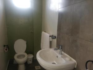 Łazienka z białą toaletą i umywalką w obiekcie Casa nostra w mieście Kakamega
