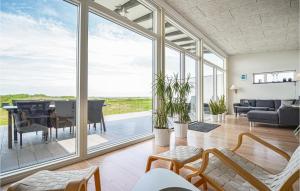 エーベルトフトにあるAmazing Home In Ebeltoft With House Sea Viewの大きなガラスの壁が備わるリビングルーム