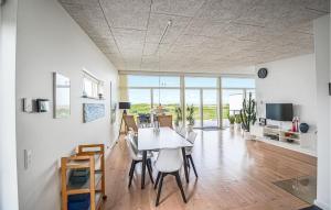 エーベルトフトにあるAmazing Home In Ebeltoft With 3 Bedrooms And Wifiのダイニングルーム、リビングルーム(テーブル、椅子付)