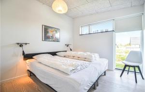 エーベルトフトにあるAmazing Home In Ebeltoft With House Sea Viewのベッドルーム1室(白いシーツと椅子付)