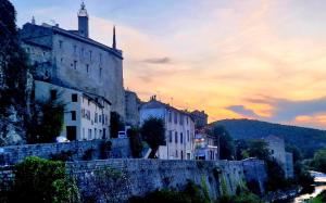 stary budynek przy ulicy miejskiej z zachodem słońca w obiekcie Maison ancienne romantique avec terrasse panoramique w mieście Vaison-la-Romaine