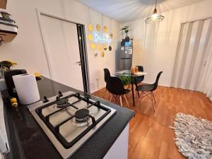 uma cozinha com um fogão e uma mesa com cadeiras em Colmena House Villa Alemana em Villa Alemana