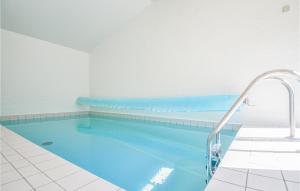 エーベルトフトにあるLovely Home In Ebeltoft With Private Swimming Pool, Can Be Inside Or Outsideの青い水とウォータースライダー付きの大型スイミングプール