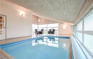エーベルトフトにあるAwesome Home In Ebeltoft With Private Swimming Pool, Can Be Inside Or Outsideの建物内の青い水のスイミングプール