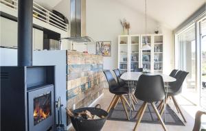 cocina con chimenea, mesa y sillas en Stunning Home In Brovst With Kitchen, en Brovst