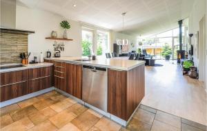 cocina con armarios de madera y lavavajillas de acero inoxidable en Amazing Home In Ebeltoft With Kitchen, en Ebeltoft