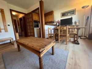 uma sala de estar com uma mesa de madeira e uma cozinha em Studio Megève, 1 pièce, 4 personnes - FR-1-453-82 em Megève