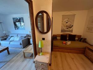 uma sala de estar com uma cama e um espelho em Studio Megève, 1 pièce, 4 personnes - FR-1-453-82 em Megève