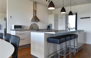 a kitchen with a counter and some black stools at Holiday Home Ringkobing Xxxix in Ringkøbing +17 photos