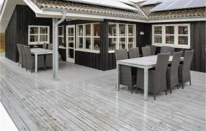 une terrasse en bois avec une table et des chaises. dans l'établissement Nice Home In Ebeltoft With 4 Bedrooms, Sauna And Wifi, à Ebeltoft