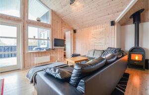 ein Wohnzimmer mit einem Ledersofa und einem Kamin in der Unterkunft Cozy Home In Ebeltoft With Sauna in Ebeltoft
