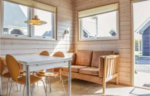 a living room with a couch and a table and chairs at Hytte 19 in Thyborøn