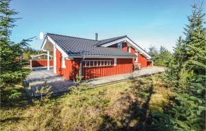 una casa rossa con un ponte nel bosco di 4 Bedroom Pet Friendly Home In Fjerritslev a Fjerritslev