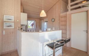 a kitchen with a bar with two stools at Beautiful Home In Fjerritslev With 4 Bedrooms, Sauna And Wifi in Fjerritslev