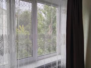 ein offenes Fenster mit einem weißen Spitzenvorhang in der Unterkunft 4 комнатная квартира на Кердери 138 in Oral