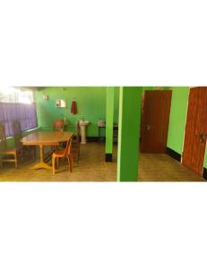 a room with a table and chairs and green walls at Manas Motel Eco Tourist Lodge, Khuthuri Jhar, Assam in Jyoti Gaon