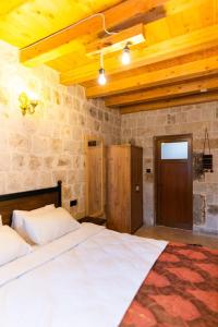 a bedroom with a large bed in a stone wall at Cappalace Stone House in Urgup
