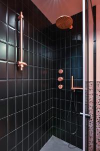 bagno con doccia e piastrelle nere di Lozenetz Gem: Cozy 1-Bedroom Apartment in Sofia a Sofia