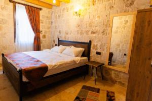 1 dormitorio con 1 cama en una habitación con ventana en Cappalace Stone House, en Ürgüp