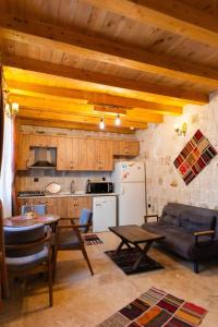eine Küche und ein Wohnzimmer mit einem Sofa und einem Tisch in der Unterkunft Cappalace Stone House in Ürgüp