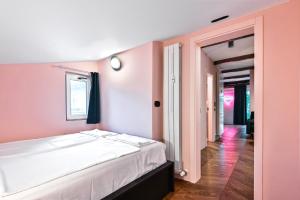 una camera con un letto bianco e una parete rosa di Lozenetz Gem: Cozy 1-Bedroom Apartment in Sofia a Sofia