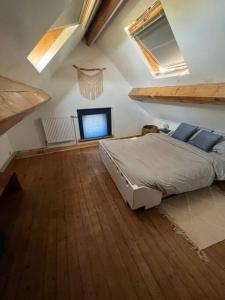 ein Schlafzimmer mit einem Bett und einem TV im Dachgeschoss in der Unterkunft Duplex avec parking à 100m de la mer in De Panne