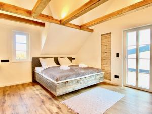 ein Schlafzimmer mit einem Bett in einem Zimmer mit Holzdecken in der Unterkunft Snug Stays Design Villa mit Garten zentral aber ruhig 400m zum Ammersee in Dießen am Ammersee