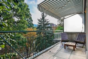 balcone con 2 sedie e un tavolo di Lozenetz Gem: Cozy 1-Bedroom Apartment in Sofia a Sofia