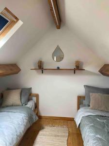 une chambre avec deux lits et un miroir au mur dans l'établissement Duplex avec parking à 100m de la mer, à La Panne