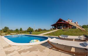 una piscina con 2 sillas y un tobogán en 3 Bedroom Cozy Home In Sveti Rok, en Sveti Rok