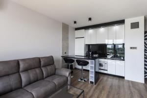 a living room with a couch and a kitchen at Apartament Bialystok in Białystok